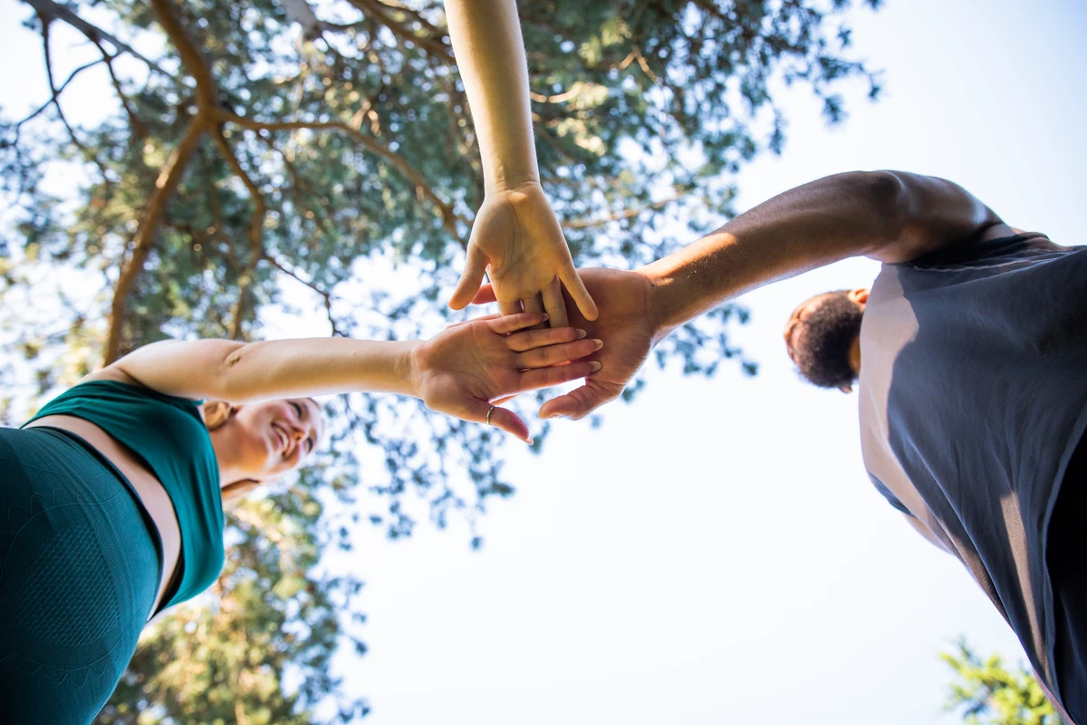 Tres personas dándose la mano para representar la discriminación positiva