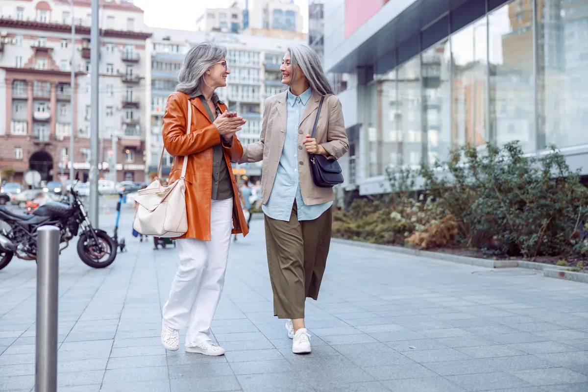 Dos mujeres mayores paseando juntas por la calle, practicando los hábitos saludables inspirados en el documental sobre los secretos de las Zonas Azules.