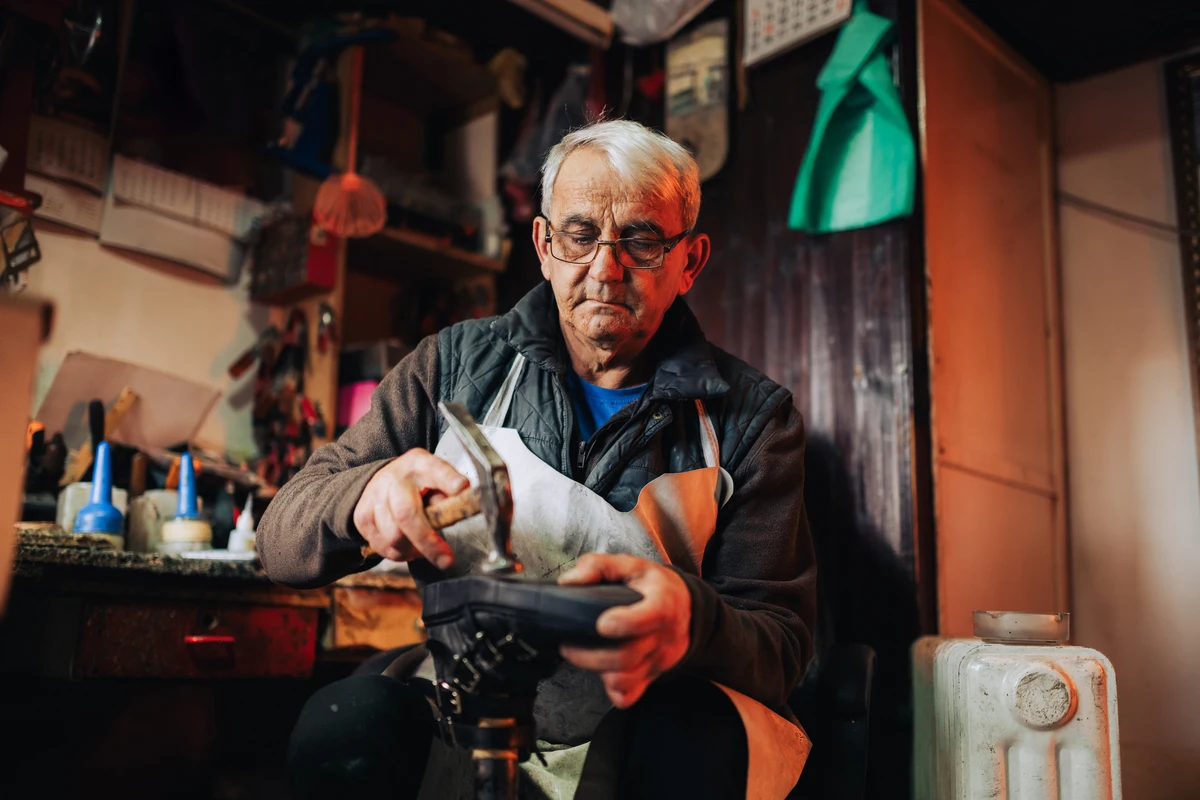 Hombre mayor en su taller, activo y beneficiado por retrasar su jubilación.